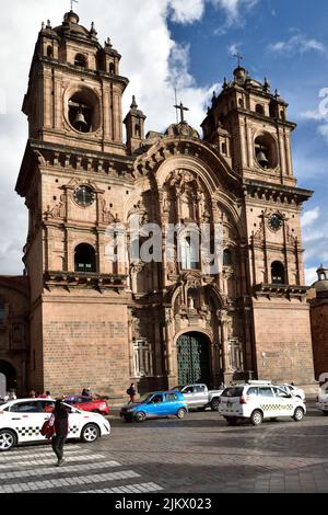 A vertical shot of the busy traffic against the Church of the Company of Jesus in Cusco, Peru Stock Photo