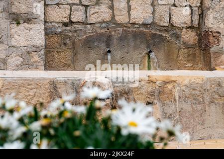 A beautiful shot of water flowing down from ancient pipes. Stock Photo