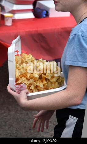 Une jeune fille achète une boîte de frites à un vendeur d'aliments lors d'un festival en plein air à Santa Fe, au Nouveau-Mexique. Banque D'Images