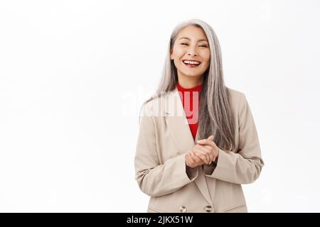 Portrait d'une femme asiatique élégante et âgée, en toute confiance, portant un blazer. Femme d'affaires assistant, debout sur fond blanc Banque D'Images