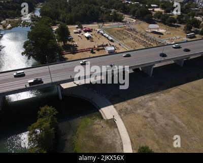Une vue aérienne des voitures roulant sur un pont au-dessus d'une rivière qui coule à travers ses rives couvertes de verdure Banque D'Images