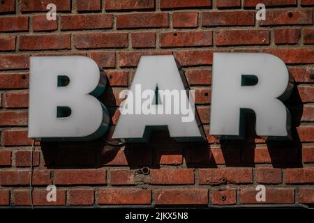 Un gros plan d'un panneau indiquant la barre sur un mur de briques rouges à Oslo, en Norvège Banque D'Images