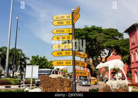 Melaka, Malaisie - octobre 2012 : panneau de signalisation jaune indiquant les distances vers diverses destinations dans le monde sur un site touristique de Th Banque D'Images