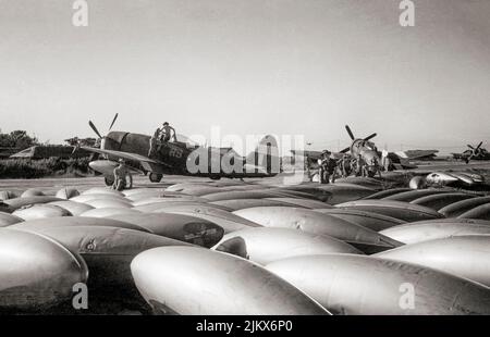 Des chars d'assaut de longue portée de 37 gallons à côté d'une République Thunderbolt Mark IIS du RAF du N° 30 Squadron, comme ils sont readiés pour une sortie à Cox's Bazaar, en Inde. Le Thunderbolt était un avion de chasse de l'époque de la Seconde Guerre mondiale produit par la compagnie aérospatiale américaine Republic Aviation de 1941 à 1945. Il pourrait une charge de bombe de 2 500 lb (1 100 kg), ce qui en fait l'un des combattants les plus lourds de la guerre. Banque D'Images