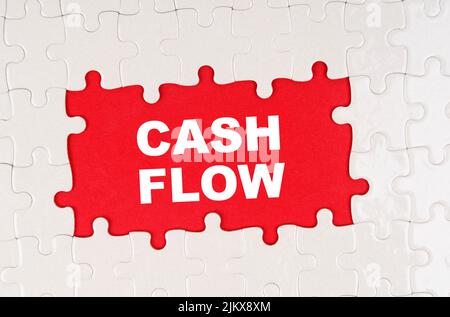 Concept commercial et financier. Au milieu des puzzles sur un fond rouge il est écrit - CASH FLOW Banque D'Images