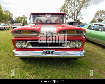 Chascomus, Argentine - 09 avril 2022 : camion de pick-up Apache Chevrolet C10 Old Red 1960-1961. Vue avant. Gril. Vert herbe nature fond. Util Banque D'Images