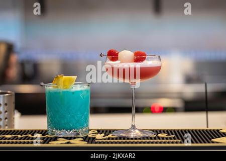 Un gros plan de cocktails colorés dans des verres décorés de fruits Banque D'Images