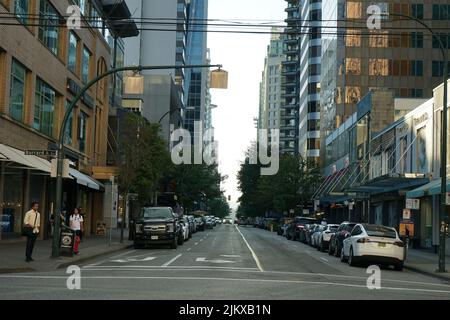 A view of tall buildings and a street with modern cars in downtown Vancouver, Canada Stock Photo