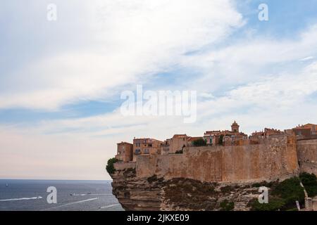 Paysage côtier de Bonifacio, Corse. Vue sur la vieille ville avec maisons en pierre sur une côte rocheuse sous ciel nuageux Banque D'Images
