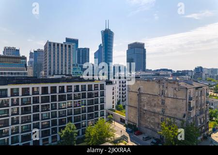 7.22.2022 Varsovie, Pologne. Vue aérienne de drone. Contraste entre la maison de briquetage d'avant-guerre et neomodern bloc noir et blanc des appartements et des gratte-ciels hauts en verre dans l'arrière-plan. Photo de haute qualité Banque D'Images