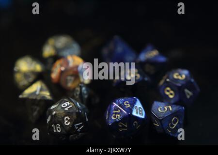 Blue metallic swirl dice with gold numbers and smoke dice with gold metallic swirls and silver numbers Stock Photo