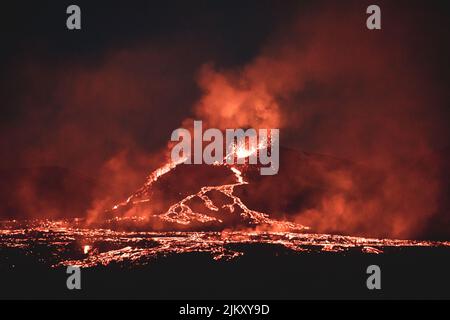 A night view of a volcano eruption in Iceland.  fiery rivers flowing down the slopes of the mountain Stock Photo