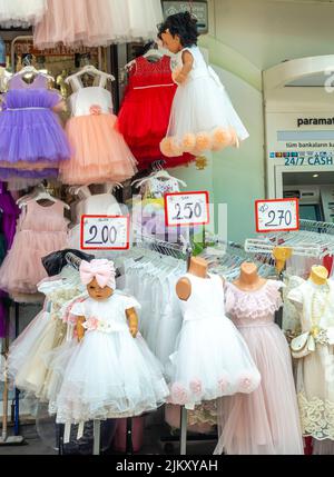 Filles d'enfants robes colorées, avec des étiquettes de prix vendues dans la rue dans le Grand Bazar, Istanbul, Turquie Banque D'Images