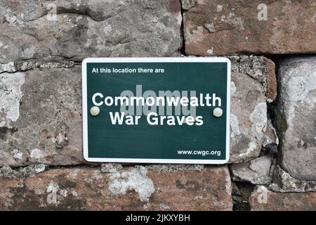 Panneau à un cimetière dans le Lake District: 'À cet endroit il y a des tombes de guerre du Commonwealth'. Banque D'Images