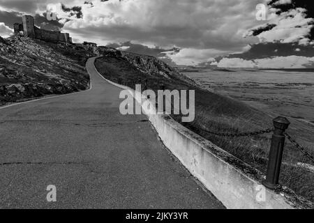 A greyscale shot of a road leading to Dobrogea County in Romania Stock Photo