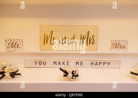 A closeup of 'Mr and Mrs' wedding decorations on the wall with text 'you make me happy' Stock Photo