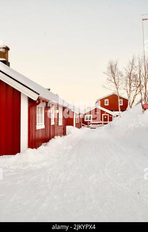 Un cliché vertical de chalets rouges sur un champ enneigé à Islas Lofoten, en Norvège Banque D'Images