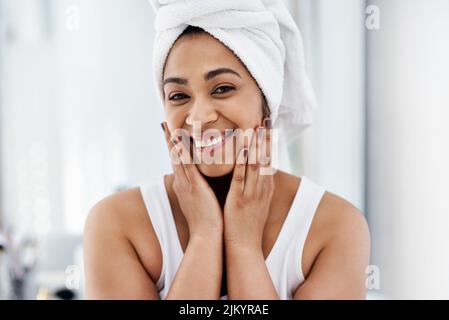 Un sourire pour égayer votre journée. Une jeune femme qui passe par sa routine de beauté à la maison. Banque D'Images