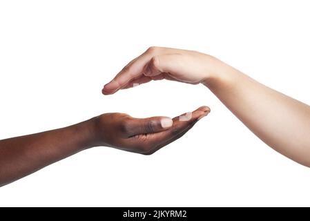 Tout ce qui vous rassemble en vaut la peine. Court studio tourné de deux femmes atteignant leurs mains l'une contre l'autre sur un fond blanc. Banque D'Images