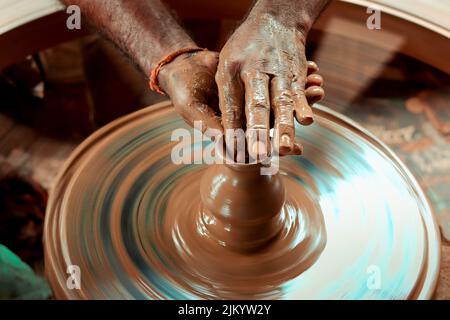 Photo à vitesse d'obturation lente d'une main de potier faisant un pot à partir d'une roue de poterie. Banque D'Images