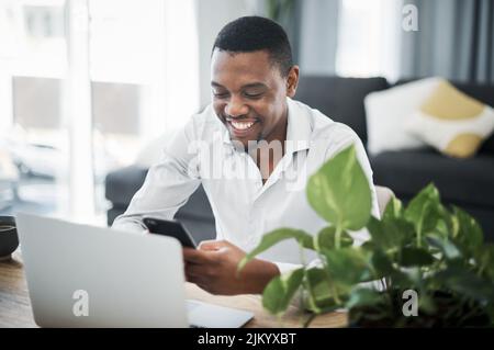 Rester en contact avec les clients grâce à la technologie. Un beau jeune homme d'affaires assis seul et utilisant la technologie pour travailler à domicile. Banque D'Images