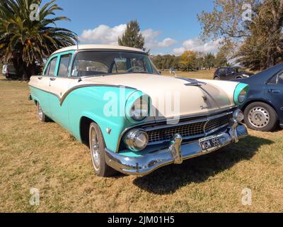 Chascomus, Argentine - 9 avril 2022 : Old aqua and White Two tone Ford Fairlane Town Sedan V8 quatre portes 1955. Nature vert herbe et arbres fond. C Banque D'Images