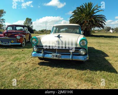 Chascomus, Argentine - 9 avril 2022 : Old aqua and White Two tone Ford Fairlane Town Sedan V8 quatre portes 1955. Vue avant. Nature herbe verte et arbres b Banque D'Images