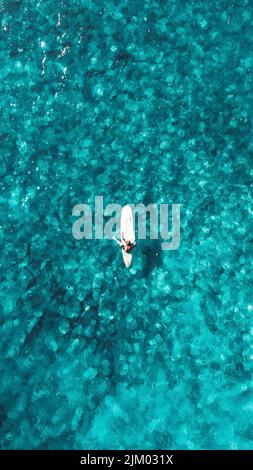 An amazing aerial top view of white boat in the sea Banque D'Images