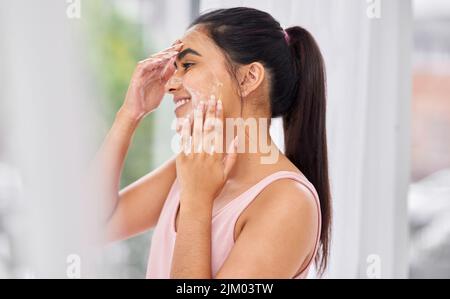 Une belle peau est le résultat d'une bonne routine de soin de la peau. Une jeune femme lavant son visage dans la salle de bains. Banque D'Images