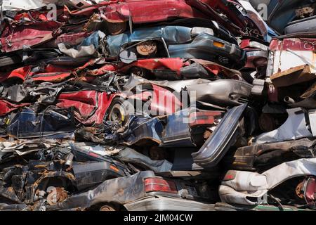 Empilé et écrasé des automobiles mises au rebut dans un parc de recyclage de ferraille. Banque D'Images