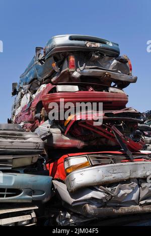 Empilé et écrasé des automobiles mises au rebut dans un parc de recyclage de ferraille. Banque D'Images