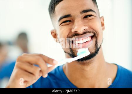 Brosse deux fois par jour garde le dentiste loin. Un jeune homme se prépare à se brosser les dents. Banque D'Images
