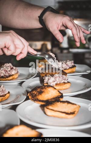 Chef finissant son assiette et presque prêt à servir à la table. Mains seulement. Enfin, la vinaigrette Banque D'Images