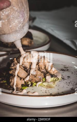 Chef finissant son assiette et presque prêt à servir à la table. Mains seulement. Enfin, la vinaigrette Banque D'Images