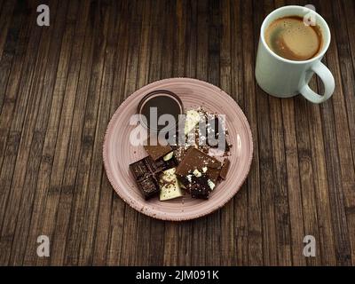 top view of a selection of white, milk and dark chocolate, melted chocolate and a mug of coffee Banque D'Images
