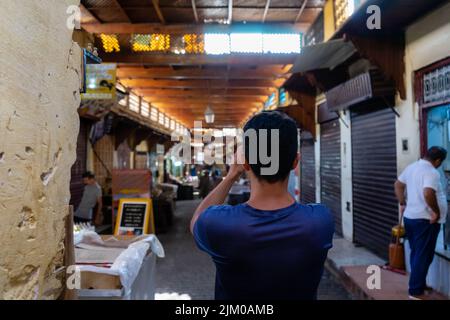 Visitor taking photos in the old medina of Fes Banque D'Images
