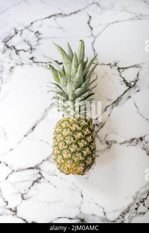 Un gros plan vertical d'ananas sur fond de marbre. Ananas comosus. Banque D'Images