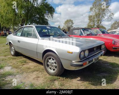 Chascomus, Argentine - 9 avril 2022: Vieux gris argent Lancia Beta coupé fin 1970s garé sur l'herbe. Arbres de la nature en arrière-plan. Salon de la voiture classique Banque D'Images