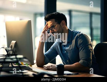 Est la semaine terminée. Photo d'un jeune homme d'affaires stressé pendant une nuit de travail tardive. Banque D'Images