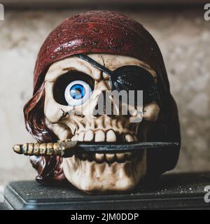 A closeup shot of a pirate skull figure with a knife in its mouth Stock Photo