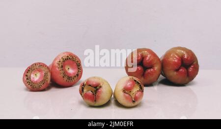 A closeup of rose apples of different ages and sizes isolated on a white background Banque D'Images