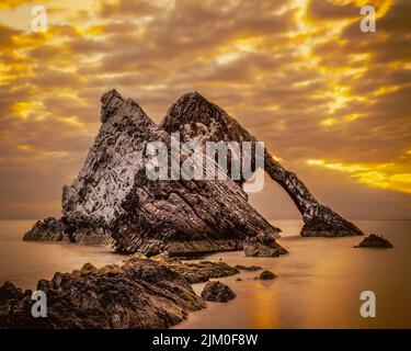Lever du soleil à Bow Fiddle Rock une arche de mer naturelle près de Portknokie dans le nord-est de l'Écosse, une attraction touristique et lieu de nidification pour de nombreux oiseaux de mer Banque D'Images