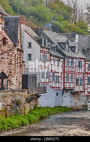 A vertical shot of houses on a riverbank in a little town Monreal in Eifel, Germany Stock Photo