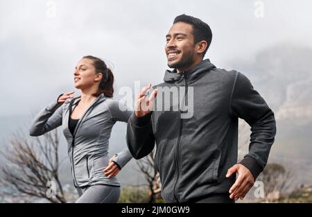 La course sur sentier améliore chaque aspect de votre forme physique. Un jeune homme et une jeune femme sportifs qui s'exécutent ensemble à l'extérieur. Banque D'Images