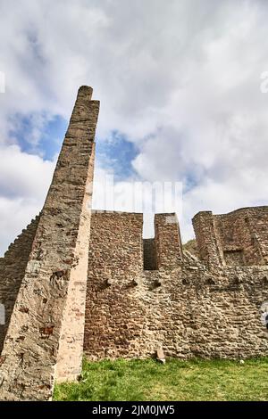 A vertical shot of the Ruins of the Lowenburg castle in Monreal Eifel in Germany with a blue cloudy sky Stock Photo
