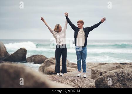 Être avec vous rend tout mieux. Un couple qui a l'air gai tout en passant du temps ensemble à la plage. Banque D'Images