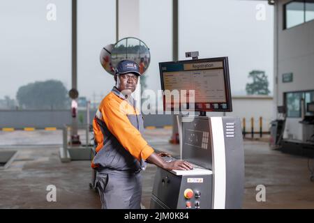 Un ingénieur noir exploitant une machine à point de contrôle auto-express tout en portant un uniforme Banque D'Images