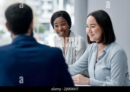 Rester réceptive aux idées des autres. Une femme d'affaires ayant une réunion avec ses collègues dans un bureau. Banque D'Images