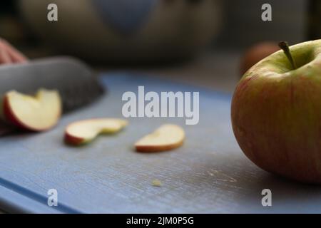 Une pomme en gros plan sur une planche à découper Banque D'Images