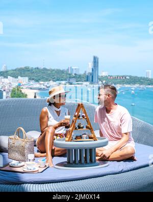 Un couple d'hommes et de femmes ayant le thé de l'après-midi sur un bar sur le toit à Pattaya en Thaïlande. . Une journée ensoleillée à Pattaya Banque D'Images